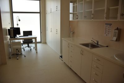 Na zdjęciu gabinet lekarski, białe meble i komputer